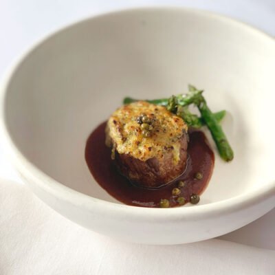 Filé em crosta de Parmesão e ervas ao molho Merlot e perfume de pimenta verde