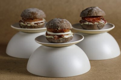 Alternative view of Mini pão australiano com tomates confit, presunto Parma e mozzarella de búfala com maionese de manjericão